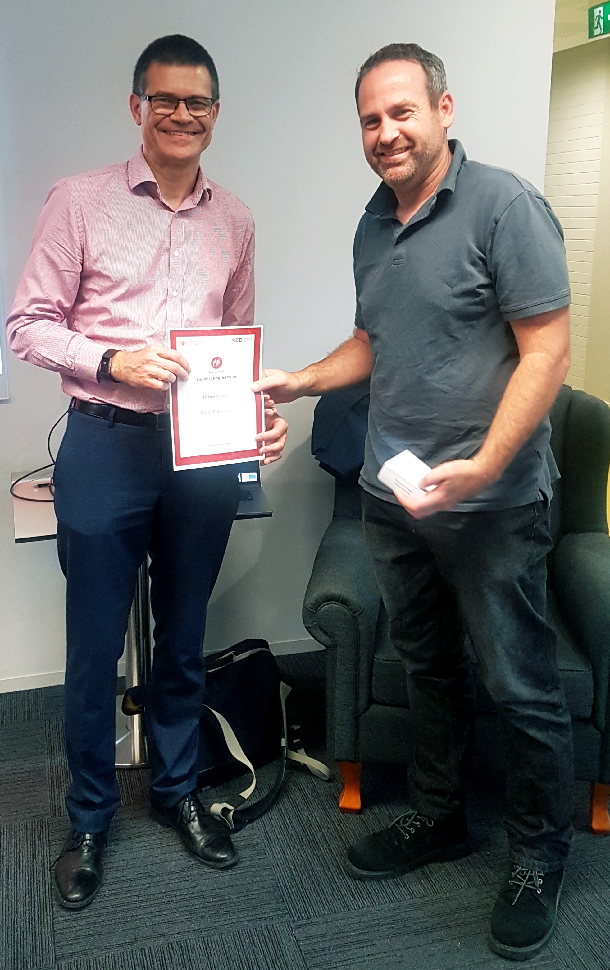 Craig Patterson receiving his 20-year service medal from Andy Vann on Wagga Wagga campus
