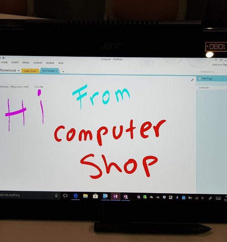 Computer monitor displaying OneNote with "Hi from Computer Shop" message